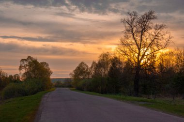 Bahar manzarası, gün doğumu. Bir köy yolu, kırsal bir arazi.