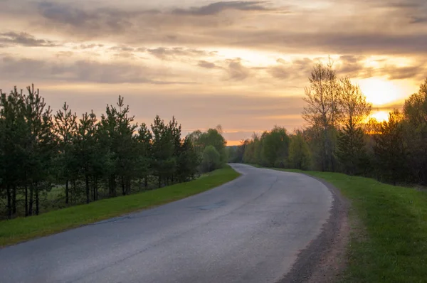 Bahar manzarası, gün doğumu. Bir köy yolu, kırsal bir arazi.