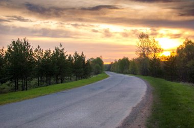 Bahar manzarası, gün doğumu. Bir köy yolu, kırsal bir arazi.