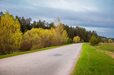 Bahar manzarası, gün doğumu. Bir köy yolu, kırsal bir arazi.