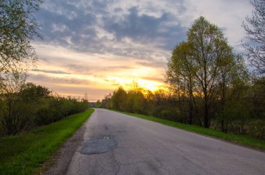 Bahar manzarası, gün doğumu. Bir köy yolu, kırsal bir arazi.