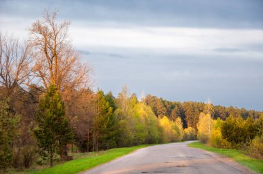 Bahar manzarası, gün doğumu. Bir köy yolu, kırsal bir arazi.