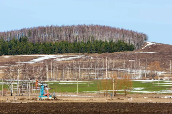 Primavera arado campo, óleo de balanço (bomba de óleo) Birch pinheiro na primavera — Fotografia de Stock