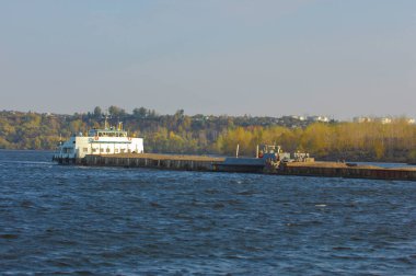 Sonbahar manzarası, nehir, nehirde yapılan çalışmalar, nehir botları, güneşli bir gün, rüzgar dalgaları yükseltiyor, suyun koyu kurşun rengi.,