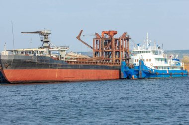 Sonbahar manzarası, nehir, nehirde yapılan çalışmalar, nehir botları, güneşli bir gün, rüzgar dalgaları yükseltiyor, suyun koyu kurşun rengi.,