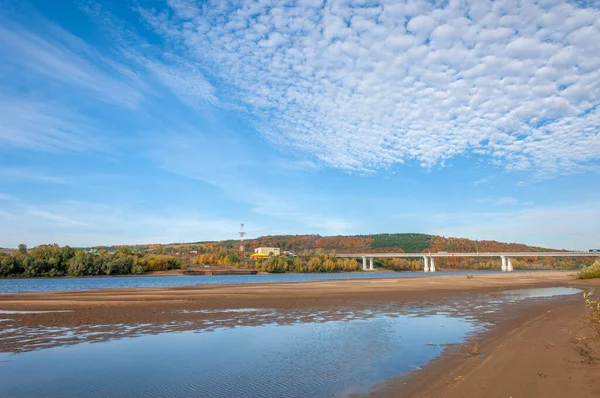 Autumn landscape river sandy shores, rifts and stretches, dark blue cold water, a sad time to catch eyes, a colorful farewell to the summer