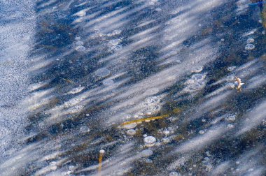 Doku yapısı arka planda beyaz kış, nehir buzu hava kabarcıkları durgun. Buz üzerindeki çizimler oluştu. Şiddetli soğuk su. Bir kanalda denize akan büyük doğal bir su akıntısı, bir göl.