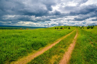 Yaz manzarası, büyük bir nehir, nehrin kıyısında çayır çiçekleri, gökyüzünde güçlü bulutlar, Kama Nehri boyunca bir turist yürüyüşü.
