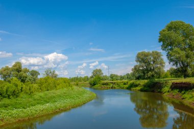 Yaz manzarası, gök gürültülü bulutlar, mavi gökyüzü, sel basmış çayır tarlaları, yaz renklerinin kokusu ve çeşitli kır çiçekleri.