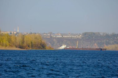 Sonbahar manzarası, koyu mavi su, son sıcak günler, nehir, ağaçlar, rüzgarlı hava, sarı-kırmızı sonbahar yaprakları.