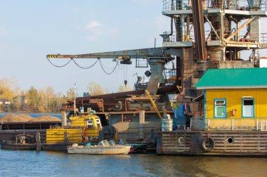 Sonbahar manzarası, nehir, nehirde yapılan çalışmalar, nehir botları, güneşli bir gün, rüzgar dalgaları yükseltiyor, suyun koyu kurşun rengi.,