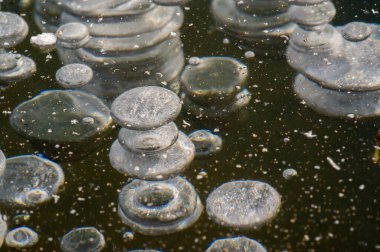 Doku yapısı arka planda beyaz kış, nehir buzu hava kabarcıkları durgun. Buz üzerindeki çizimler oluştu. Şiddetli soğuk su. Bir kanalda denize akan büyük doğal bir su akıntısı, bir göl.