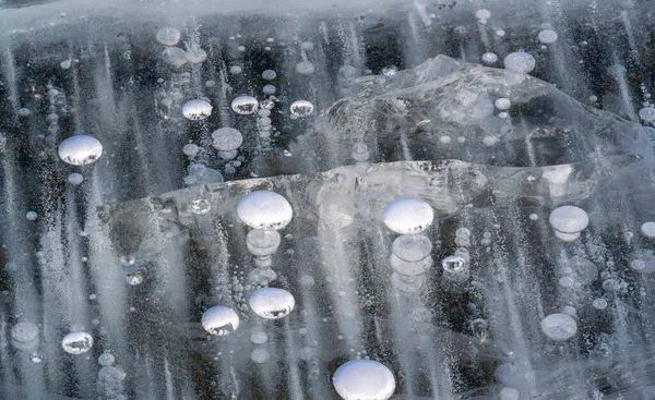 There is frost on the street, ice on the river, ice bubbles stuck in ice, unusually colorful ice architecture