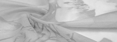 Doku, arka plan, gri çiçekli beyaz ipek süs. Kumaşın bir Jacquard dokuması var. Bu kumaş sayesinde yumuşak bir şekilde parıldayan saten bölümler elde etti.