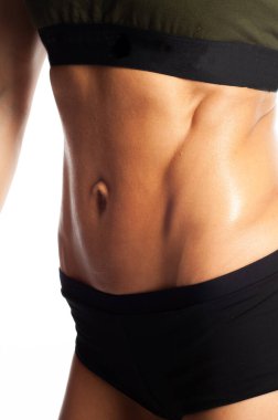 Beyaz arka planda bir modelin stüdyo fotoğrafı, sağlıklı yaşam tarzı, güzel karın kasları, kabartmalı karın kasları, hızlı bir şekilde evde bir kıza karın presi pompalaması.