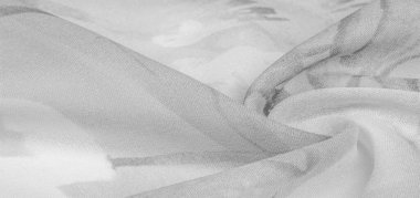 Doku, arka plan, gri çiçekli beyaz ipek süs. Kumaşın bir Jacquard dokuması var. Bu kumaş sayesinde yumuşak bir şekilde parıldayan saten bölümler elde etti.