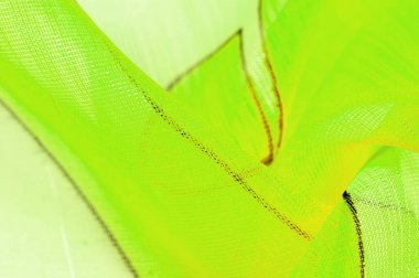 Arka plan dokusu bir organza deseni. İnce, şeffaf kumaştan bir kumaş. İnce, yapışkan ipekten bir peçe gibi. yeşil beyaz sarı gri geometrik renkler