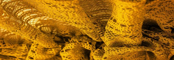 Background, texture, pattern, yellow lace fabric, thin open fabric, usually made of cotton or silk, made using loops, twisting or knitting threads in patterns