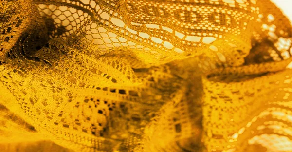 Background, texture, pattern, yellow lace fabric, thin open fabric, usually made of cotton or silk, made using loops, twisting or knitting threads in patterns