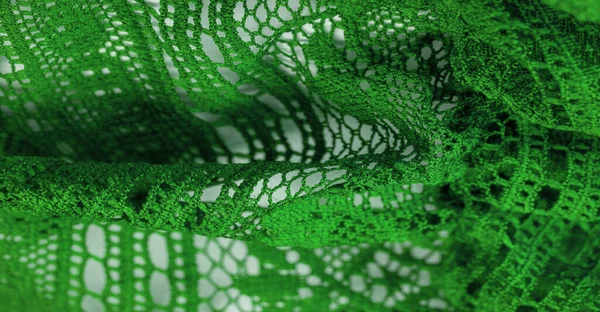 Background, texture, pattern, green lace fabric, thin open fabric, usually made of cotton or silk, made using loops, twisting or knitting threads in patterns
