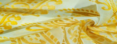 Doku, desen, koleksiyon, ipek kumaş, kadın eşarbı, bej arka planda altın pastel, basılmış altın desenli fotoğraf.