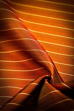 Kumaşın arkaplan dokusu, yakut kırmızısı rengi ince, güçlü, yumuşak, parlak lif kozaların üretiminde ipek böcekleri tarafından elde edilir ve iplik ve kumaş üretimi için birleştirilir..