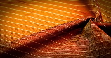 Kumaşın arkaplan dokusu, yakut kırmızısı rengi ince, güçlü, yumuşak, parlak lif kozaların üretiminde ipek böcekleri tarafından elde edilir ve iplik ve kumaş üretimi için birleştirilir..