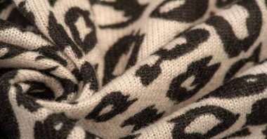 Doku, arkaplan, desen, kadın yün şalı, siyah ve bej, Afrika motifleri, yün ve modülden yapılmış, kenarları kıvrımlı bir yılan şeklinde..