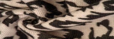 Doku, arkaplan, desen, kadın yün şalı, siyah ve bej, Afrika motifleri, yün ve modülden yapılmış, kenarları kıvrımlı bir yılan şeklinde..