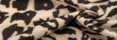 Doku, arkaplan, desen, kadın yün şalı, siyah ve bej, Afrika motifleri, yün ve modülden yapılmış, kenarları kıvrımlı bir yılan şeklinde..