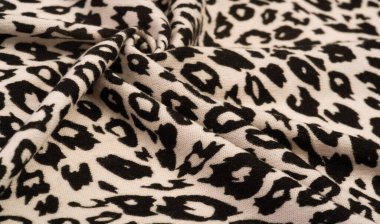 Doku, arkaplan, desen, kadın yün şalı, siyah ve bej, Afrika motifleri, yün ve modülden yapılmış, kenarları kıvrımlı bir yılan şeklinde..