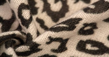 Doku, arkaplan, desen, kadın yün şalı, siyah ve bej, Afrika motifleri, yün ve modülden yapılmış, kenarları kıvrımlı bir yılan şeklinde..