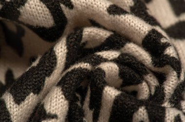 Doku, arkaplan, desen, kadın yün şalı, siyah ve bej, Afrika motifleri, yün ve modülden yapılmış, kenarları kıvrımlı bir yılan şeklinde..