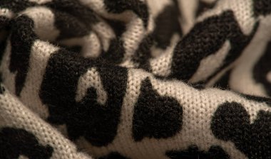 Doku, arkaplan, desen, kadın yün şalı, siyah ve bej, Afrika motifleri, yün ve modülden yapılmış, kenarları kıvrımlı bir yılan şeklinde..