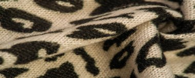 Doku, arkaplan, desen, kadın yün şalı, siyah ve bej, Afrika motifleri, yün ve modülden yapılmış, kenarları kıvrımlı bir yılan şeklinde..