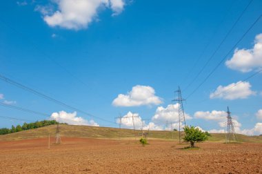 Yaz manzarası, enerji sütunlarının yapısı. Mavi gökyüzüne karşı yüksek voltajlı elektrik direğinin ayrıntıları