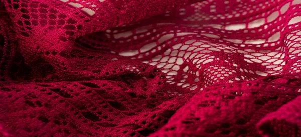 Background, texture, pattern, red lace fabric, thin open fabric, usually made of cotton or silk, made using loops, twisting or knitting threads in patterns