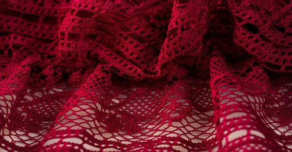 Background, texture, pattern, red lace fabric, thin open fabric, usually made of cotton or silk, made using loops, twisting or knitting threads in patterns