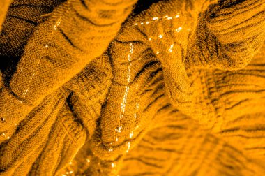 Arkaplan deseninin dokusu, süs süsü, altın sarısı kıvrımlı kumaş, paralel ya da çapraz kıvrımlı kumaş; böyle bir kumaştan çıkan ürünler.