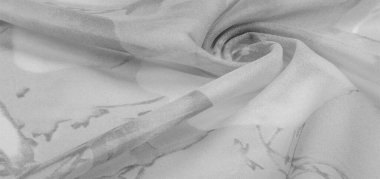 Doku, arka plan, gri çiçekli beyaz ipek süs. Kumaşın bir Jacquard dokuması var. Bu kumaş sayesinde yumuşak bir şekilde parıldayan saten bölümler elde etti.