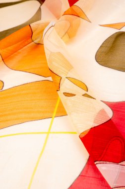 Arka plan dokusu bir organza deseni. İnce, şeffaf kumaştan bir kumaş. İnce, yapışkan ipekten bir peçe gibi. yeşil kırmızı kırmızı geometrik renkler