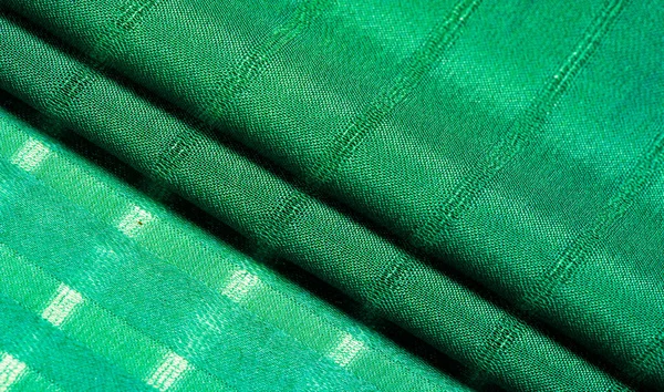 Texture, background, pattern, simple green fabric with lines. The lines formed by the extraction of the thread,