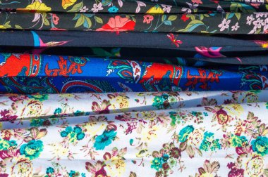 Doku arka planı, desen. Bir yığın halinde bir masaya yığılmış farklı kumaşlar