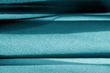 Doku, arka plan, desen, turkuaz kumaş. Bu alışılmadık bir kumaş ve zengin ve kalın bir dokusu var. Kumaşın içine inşa edilmiş tasarımlarla sıkıca örülmüş.