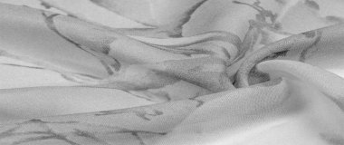 Doku, arka plan, gri çiçekli beyaz ipek süs. Kumaşın bir Jacquard dokuması var. Bu kumaş sayesinde yumuşak bir şekilde parıldayan saten bölümler elde etti.