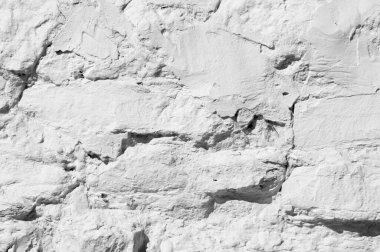 Doku arka planı, desen. Duvar granit taşlarla kaplı ve kireçle beyaz badanalı. bir arazi alanını içine alan veya bölen sürekli bir dikey tuğla veya taş yapı.