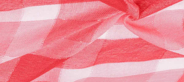Texture background pattern silk scarf female red in color with a metal stripe. The scarf is decorated with a delicate patchwork pattern in pastel shades of abstract Scotlandor motifs checked fabric