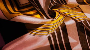 Doku, arkaplan, sarı çizgili ipek kumaş. Bu kumaşın tasarımı muhteşem bir yeleğin görünümünü temsil eden beyaz tavşan mozaiğine adanmıştır..