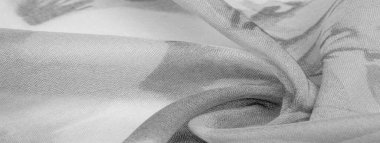 Doku, arka plan, gri çiçekli beyaz ipek süs. Kumaşın bir Jacquard dokuması var. Bu kumaş sayesinde yumuşak bir şekilde parıldayan saten bölümler elde etti.