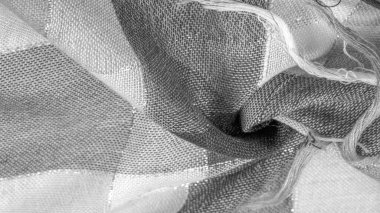 Doku, arkaplan, ipek atkı siyah beyaz, metal şeritli. Eşarp, soyut İskoç motifleriyle pastel renklerle hassas bir yama deseniyle süslenmiş. kontrol edilen kumaş